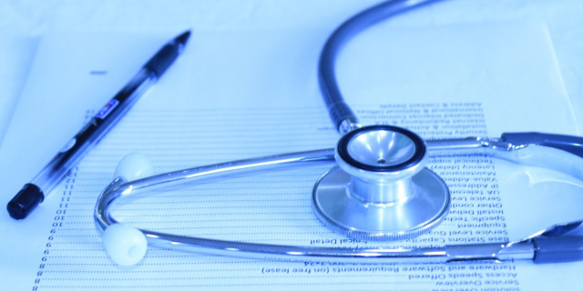 stethoscope and pen lying on piece of paper.