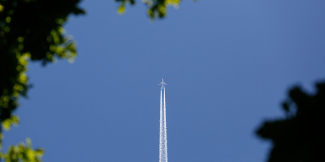 Plane flying upward in blue sky.